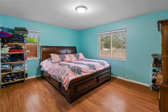 bedroom with multiple windows and hardwood / wood-style flooring