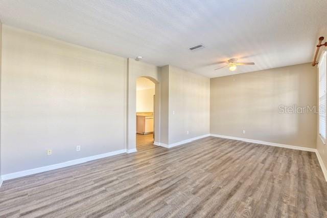 empty room with ceiling fan and light hardwood / wood-style floors