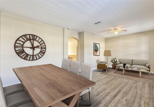 dining room featuring ceiling fan, a textured ceiling, and light hardwood / wood-style floors