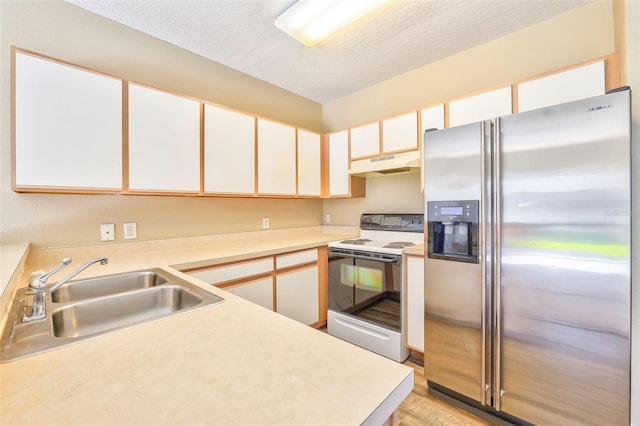 kitchen featuring white cabinetry, sink, stainless steel fridge, and white range with electric cooktop