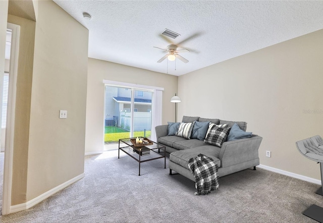 carpeted living room with ceiling fan and a textured ceiling