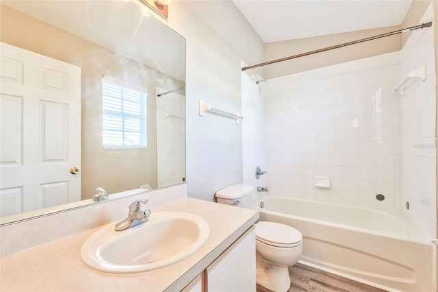 full bathroom with tiled shower / bath, vanity, toilet, and wood-type flooring