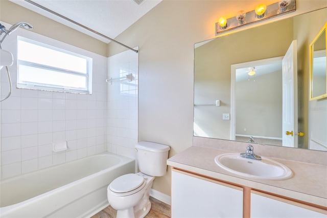 full bathroom with tiled shower / bath, vanity, and toilet