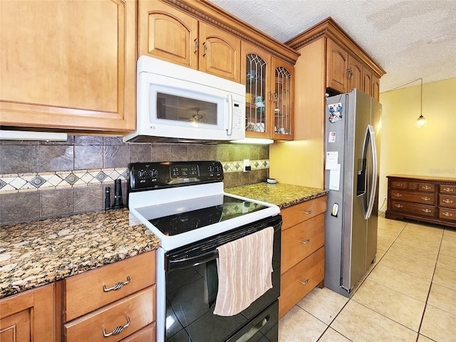 kitchen with light tile patterned flooring, electric range oven, decorative backsplash, dark stone counters, and stainless steel refrigerator with ice dispenser