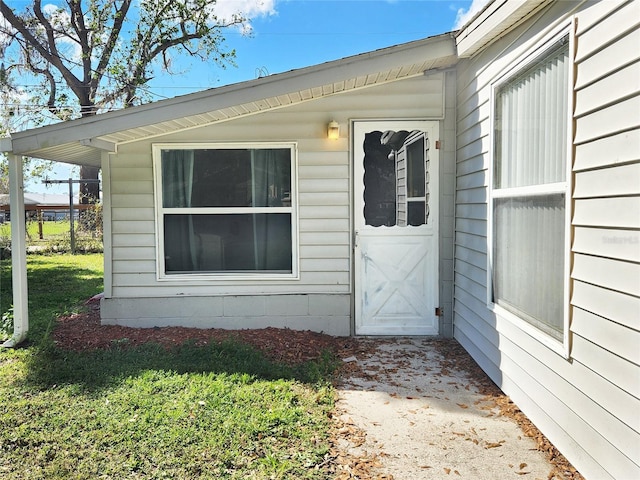 view of exterior entry with a yard