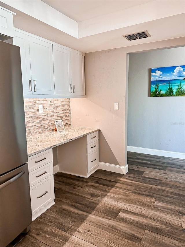 unfurnished office featuring built in desk and dark hardwood / wood-style flooring