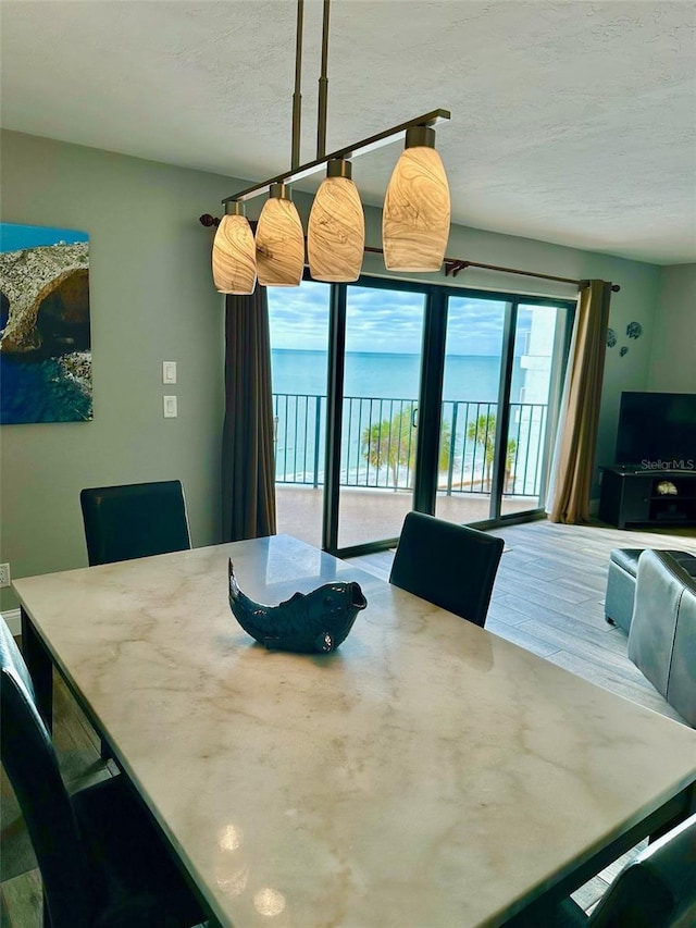 dining area with hardwood / wood-style floors and a textured ceiling