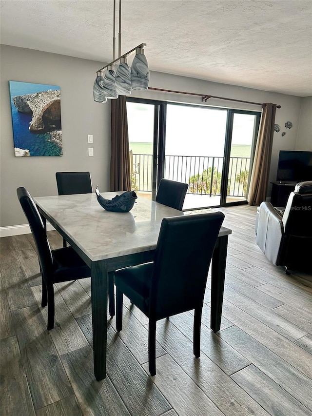 dining area featuring a textured ceiling and hardwood / wood-style floors