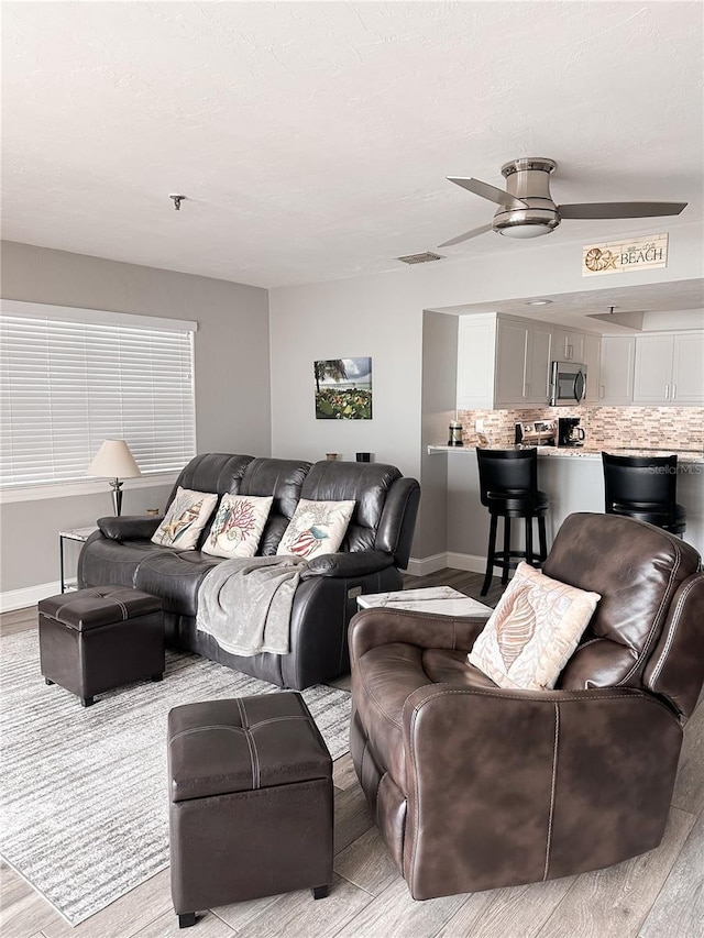 living room with ceiling fan and light wood-type flooring