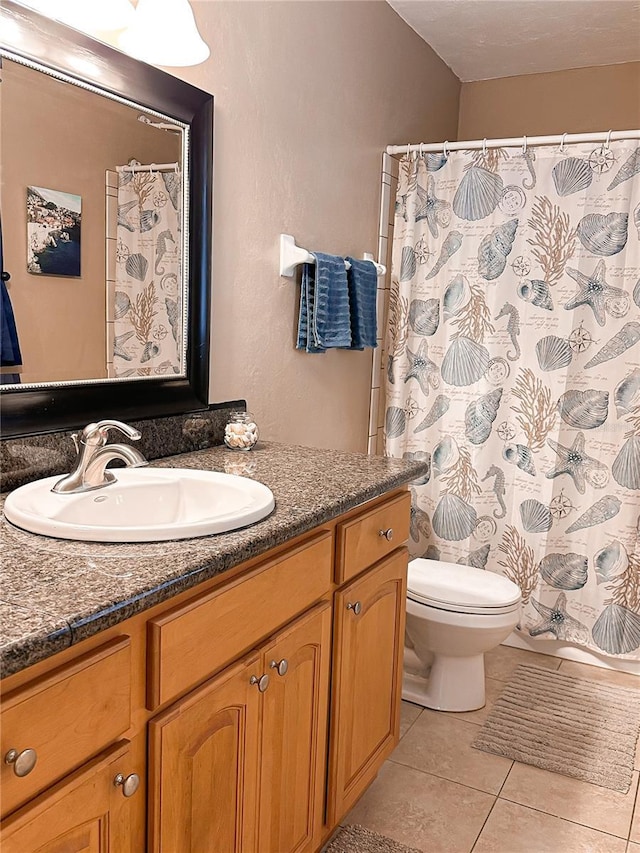 bathroom with tile patterned flooring, vanity, and toilet