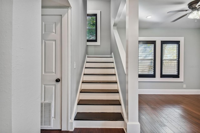 stairs featuring hardwood / wood-style flooring and ceiling fan