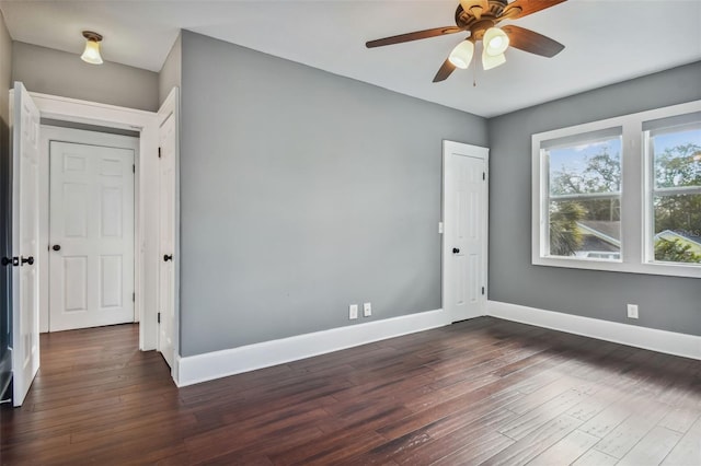 empty room with ceiling fan and dark hardwood / wood-style floors