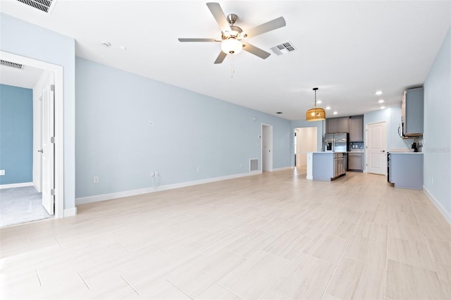 unfurnished living room with ceiling fan