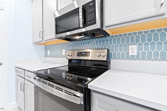 kitchen featuring tasteful backsplash, white cabinetry, and appliances with stainless steel finishes