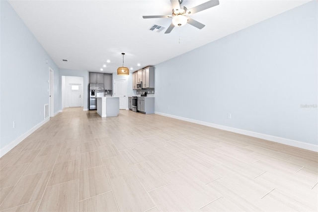 unfurnished living room featuring ceiling fan