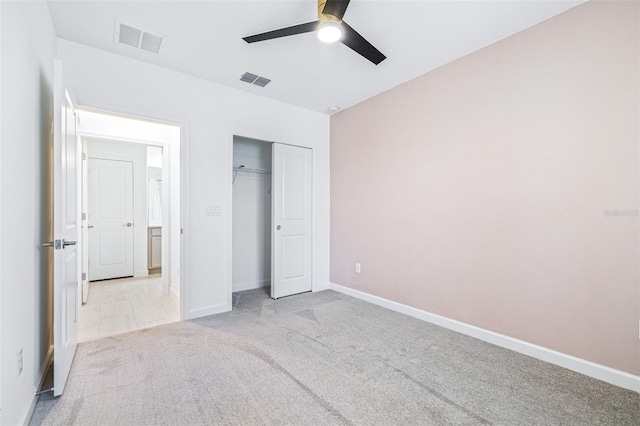 unfurnished bedroom featuring ceiling fan, light colored carpet, and a closet