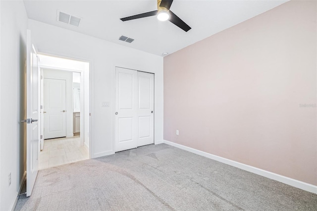 unfurnished bedroom with light carpet, a closet, and ceiling fan