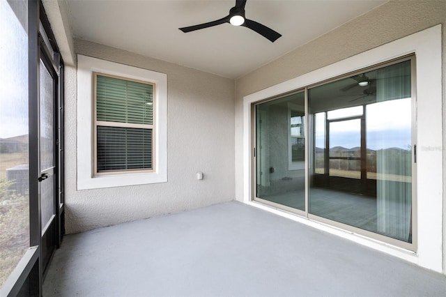 unfurnished sunroom with ceiling fan