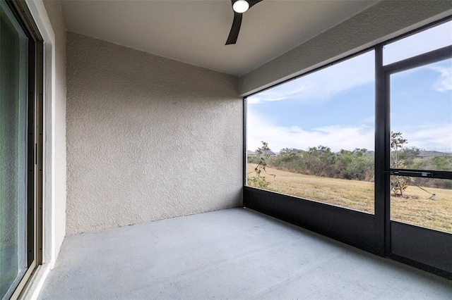 unfurnished sunroom featuring a wealth of natural light and ceiling fan