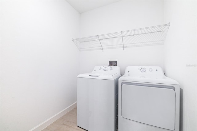 washroom featuring washer and clothes dryer and light hardwood / wood-style floors