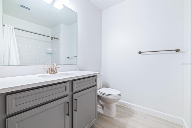 bathroom featuring vanity, curtained shower, and toilet