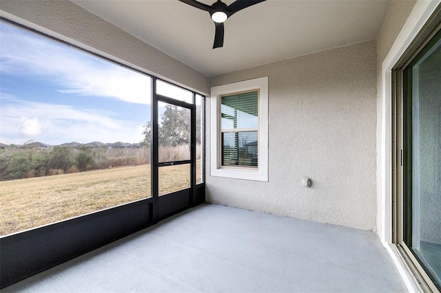 sunroom with a mountain view and ceiling fan