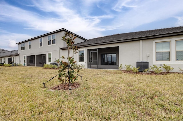 back of property with a sunroom, central air condition unit, and a lawn