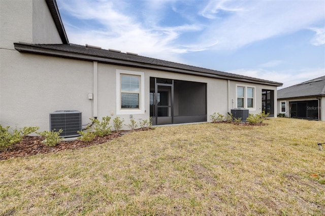 rear view of property with a sunroom, a lawn, and central air condition unit