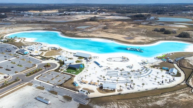 birds eye view of property featuring a water view and a beach view