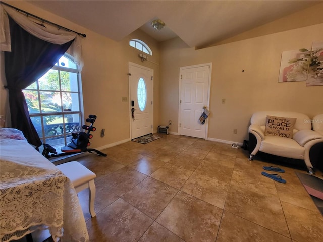 foyer entrance featuring tile patterned flooring and vaulted ceiling