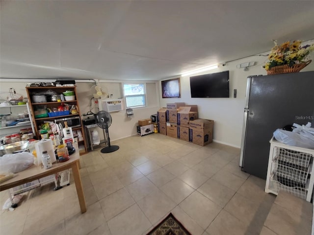 basement with stainless steel refrigerator and light tile patterned floors