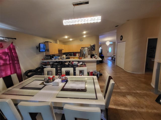 dining room with lofted ceiling and dark tile patterned flooring