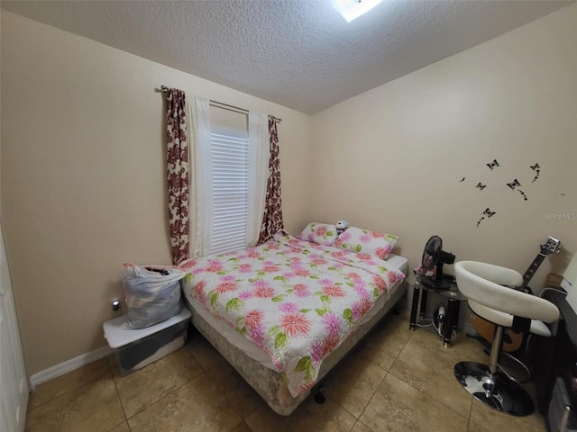 bedroom with tile patterned floors and a textured ceiling