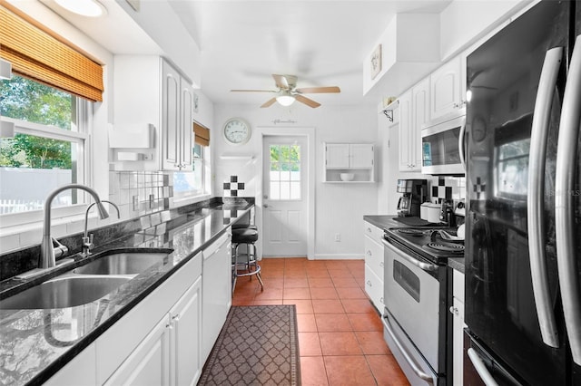 kitchen featuring sink, light tile patterned floors, stainless steel appliances, and white cabinets