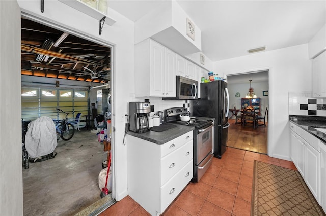 kitchen featuring stainless steel appliances, white cabinetry, tasteful backsplash, and light tile patterned floors