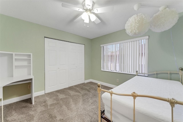 bedroom featuring ceiling fan, a closet, carpet, and a textured ceiling