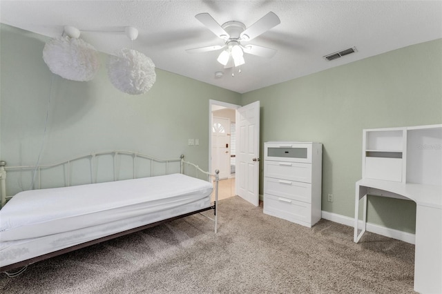 bedroom featuring ceiling fan, a textured ceiling, and carpet