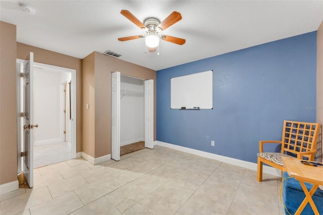 sitting room with light tile patterned floors and ceiling fan