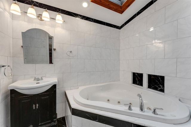 bathroom featuring tile walls, tiled tub, and vanity