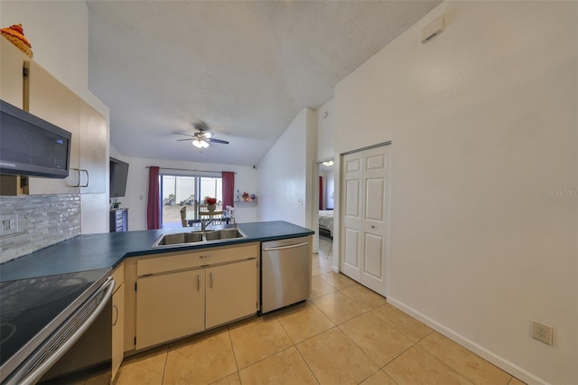 kitchen featuring sink, light tile patterned floors, stainless steel appliances, decorative backsplash, and kitchen peninsula