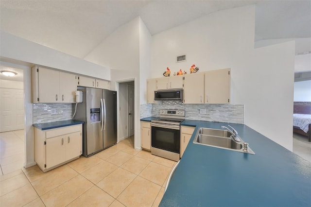 kitchen featuring sink, appliances with stainless steel finishes, tasteful backsplash, light tile patterned flooring, and cream cabinetry