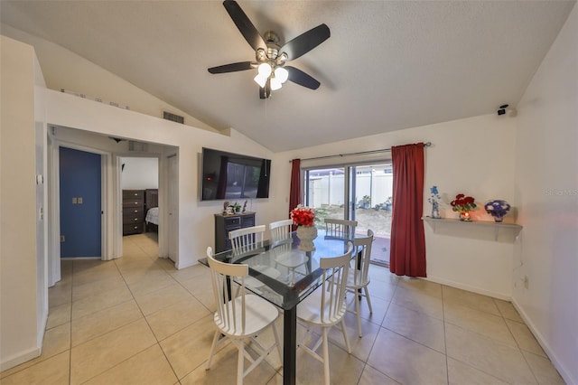 tiled dining room with ceiling fan, vaulted ceiling, and a textured ceiling