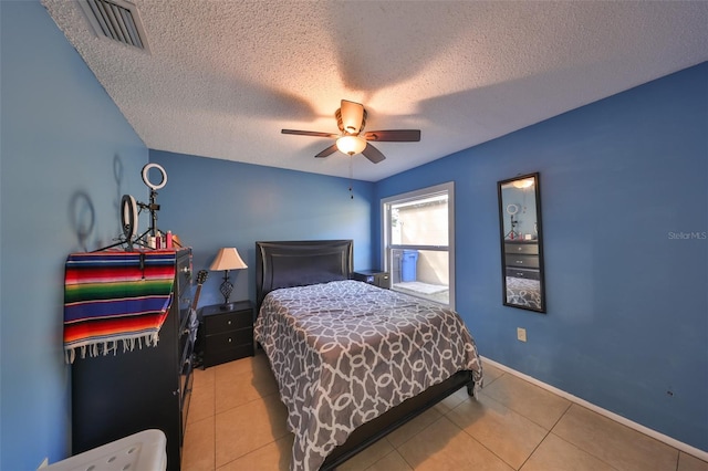 bedroom with ceiling fan, a textured ceiling, and light tile patterned floors