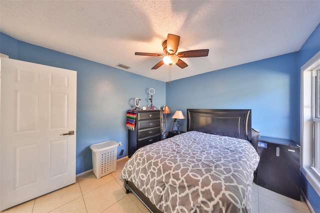 bedroom with ceiling fan, a textured ceiling, and light tile patterned floors