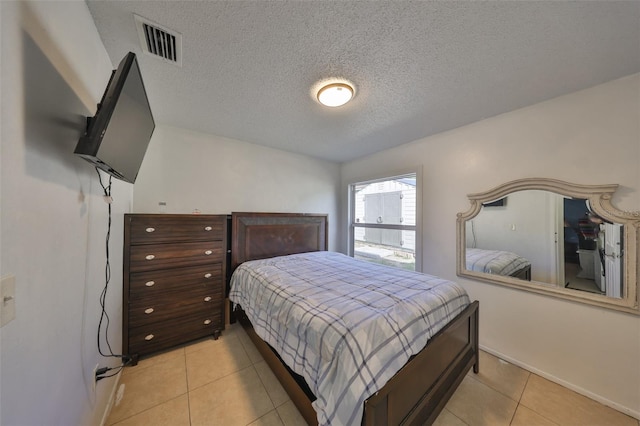 tiled bedroom with a textured ceiling