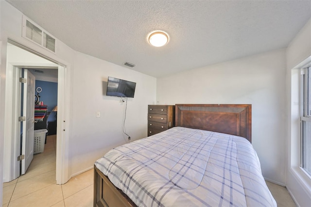 bedroom with a textured ceiling and light tile patterned floors