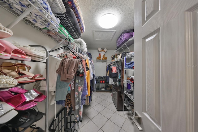 walk in closet with light tile patterned floors