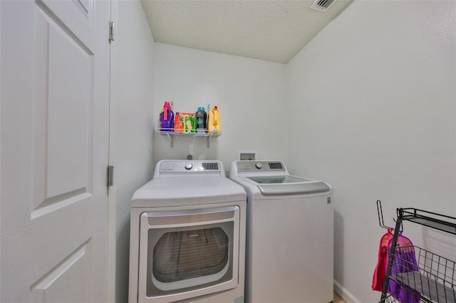 laundry room with washing machine and dryer and a textured ceiling