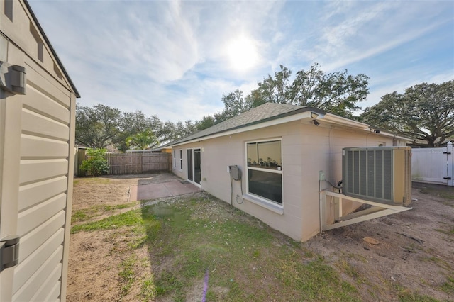 view of property exterior with central AC and a patio