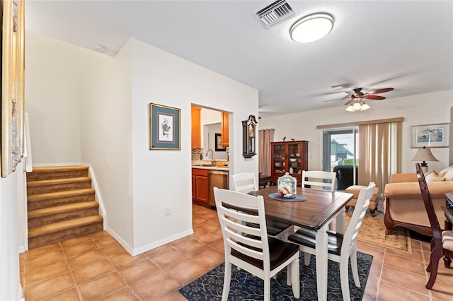 dining area with sink, light tile patterned floors, a textured ceiling, and ceiling fan